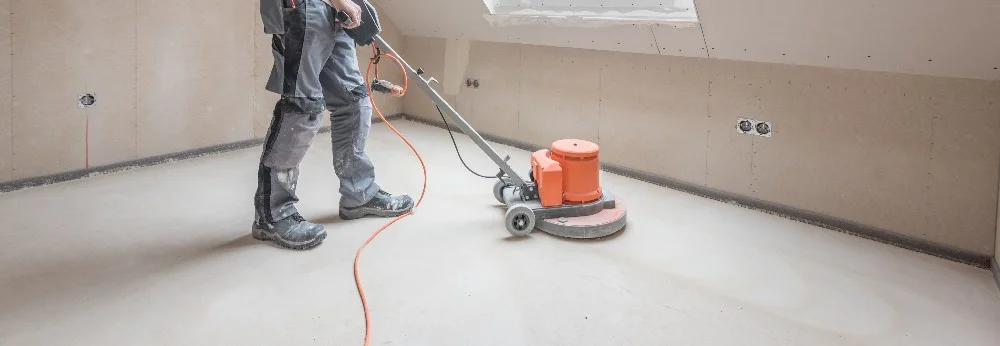 Person schleift Estrich